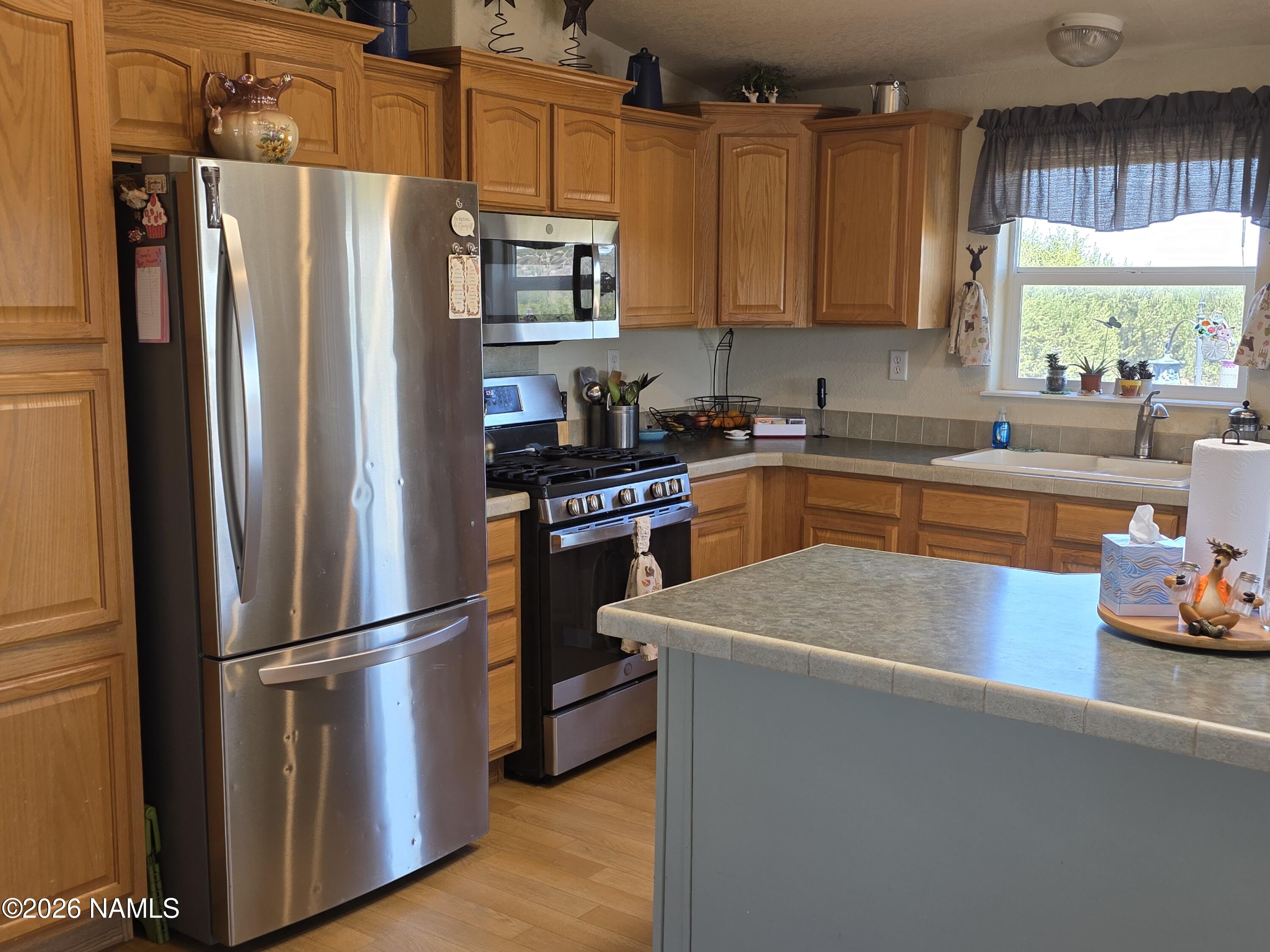 1431 East Cedar Road Williams, AZ 86046 - Photo 14 of 51 a kitchen with stainless steel appliances granite countertop a refrigerator sink and stove