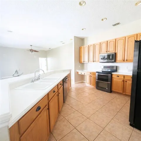a kitchen with stainless steel appliances a sink stove and cabinets