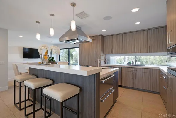 a kitchen with granite countertop a table chairs microwave and cabinets