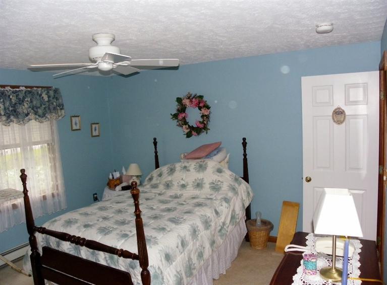 56 Shields Road Mashpee, MA 02649 - Photo 15 of 17 a bed room with a bed and a chandelier