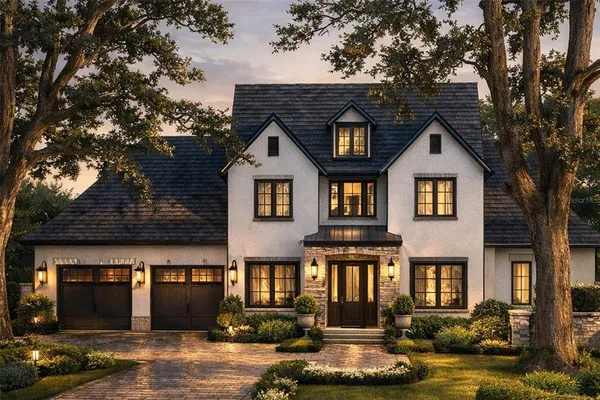 a front view of a house with garden and trees