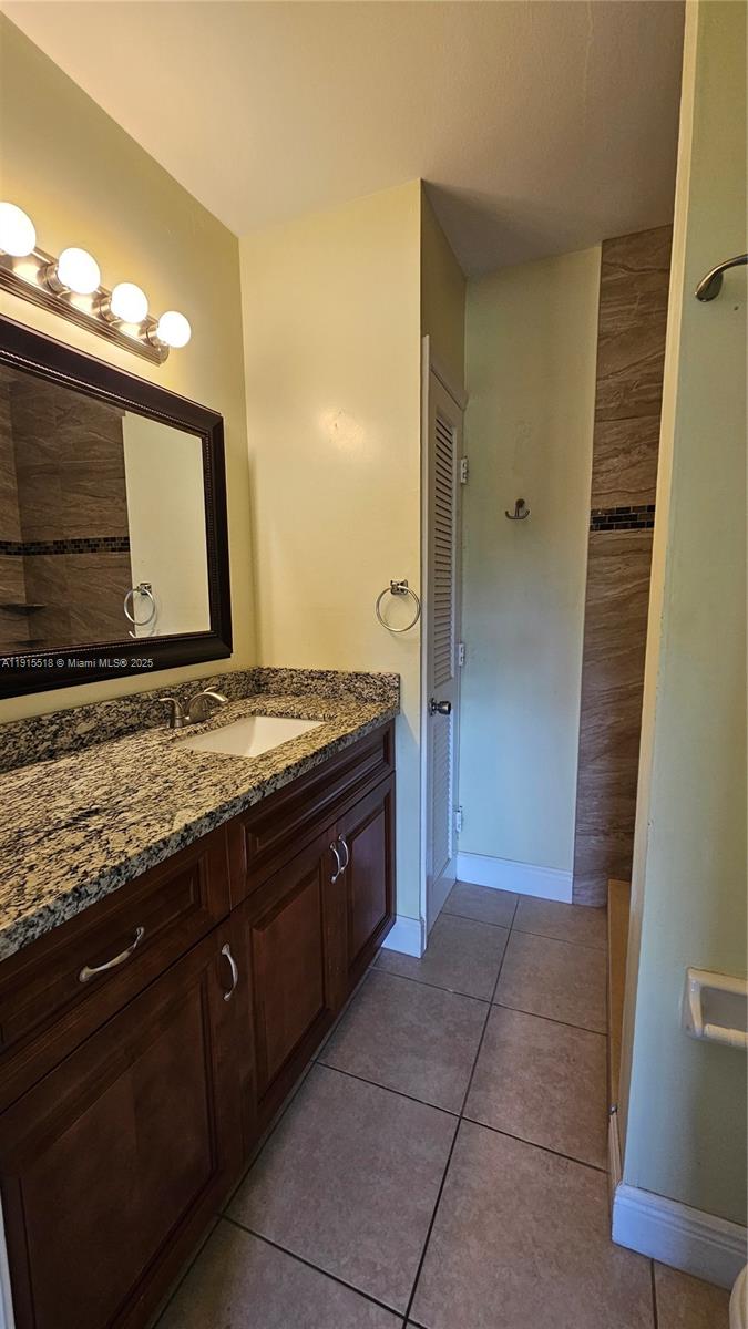 8901 Northwest 38th Drive, Unit 206 Coral Springs, FL 33065 - Photo 11 of 17 a bathroom with a granite countertop sink and a mirror