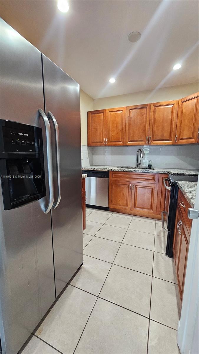 8901 Northwest 38th Drive, Unit 206 Coral Springs, FL 33065 - Photo 2 of 17 a kitchen with granite countertop a refrigerator a stove a sink a washer dryer and cabinets