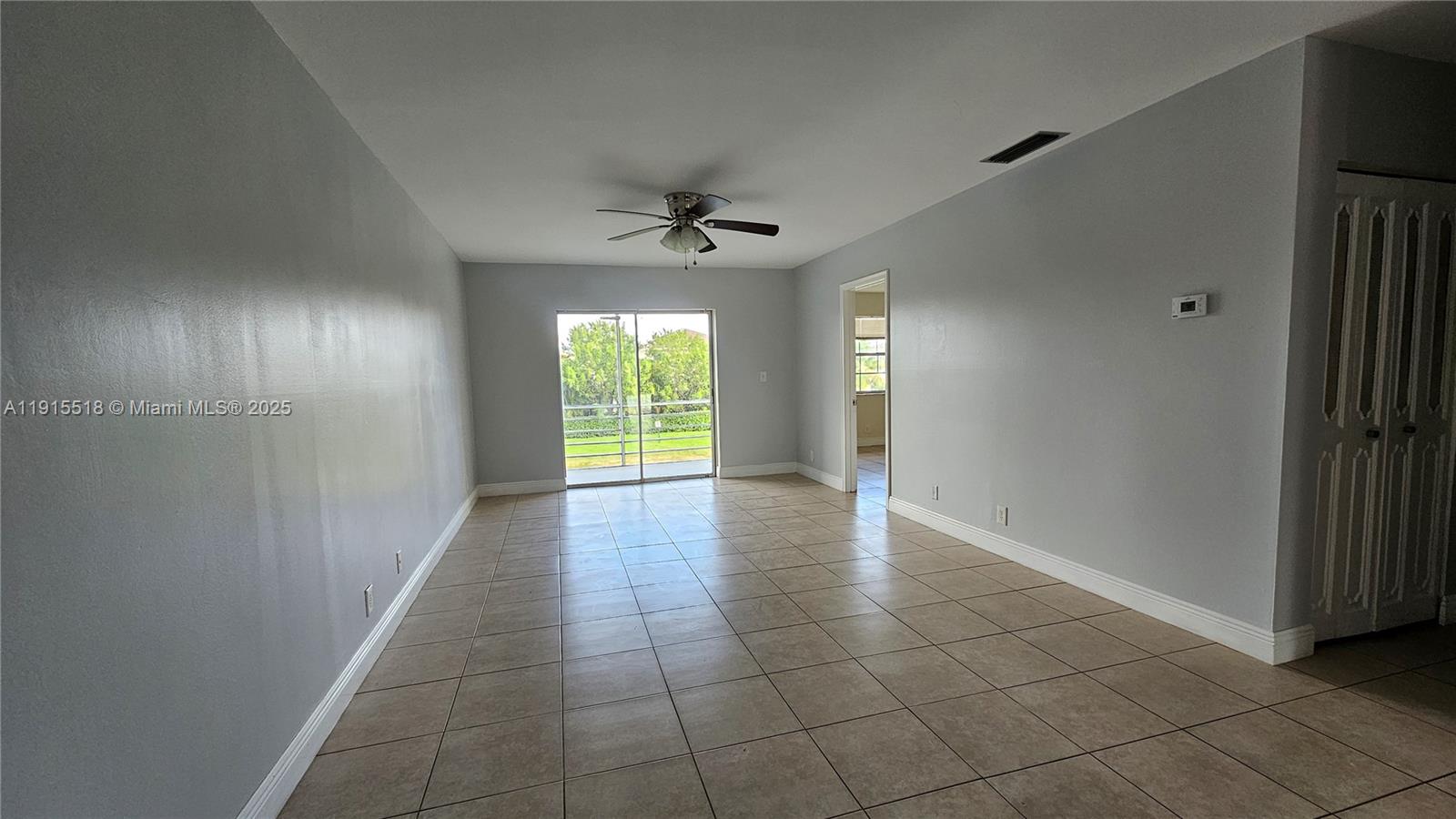 8901 Northwest 38th Drive, Unit 206 Coral Springs, FL 33065 - Photo 3 of 17 an empty room with windows and chandelier fan