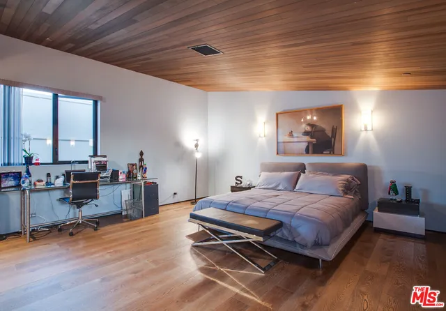 a bedroom with a bed a table and chair