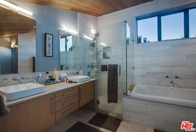 a bathroom with a double vanity sink mirror and bathtub
