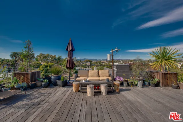 a view of a balcony with chairs and wooden floor
