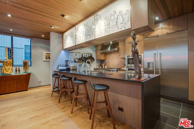 a kitchen with stainless steel appliances granite countertop a sink and a refrigerator
