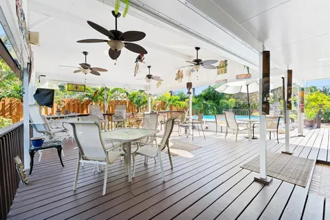 a view of a house with a yard and palm trees