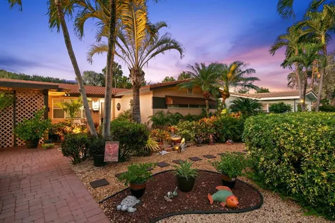 an aerial view of residential houses with outdoor space and trees