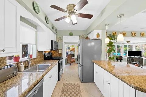 a kitchen with stainless steel appliances granite countertop a sink refrigerator and cabinets