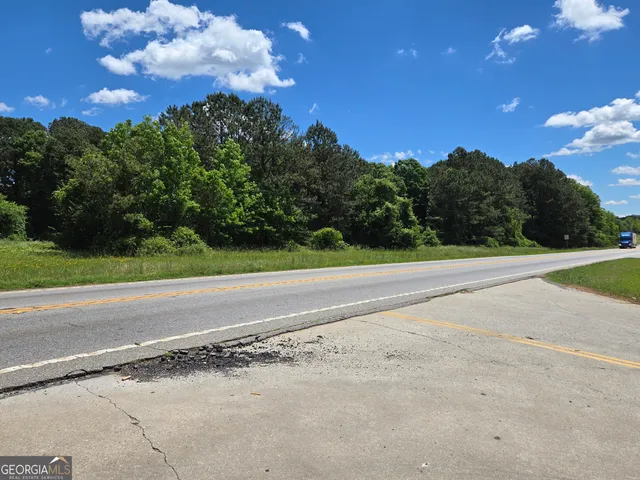 a view of a yard with flower plants and wooden fence