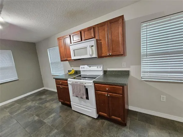 a kitchen with stainless steel appliances granite countertop a stove a sink and a microwave