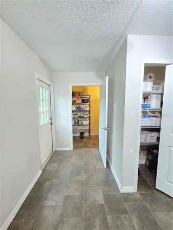 an empty room with kitchen view and closet