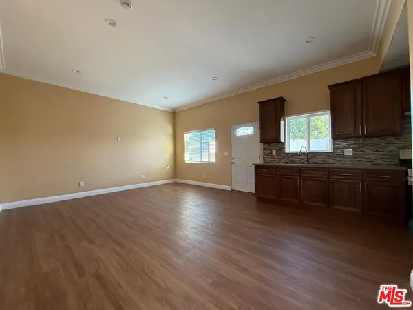 a kitchen with granite countertop wooden floors a stove and a microwave