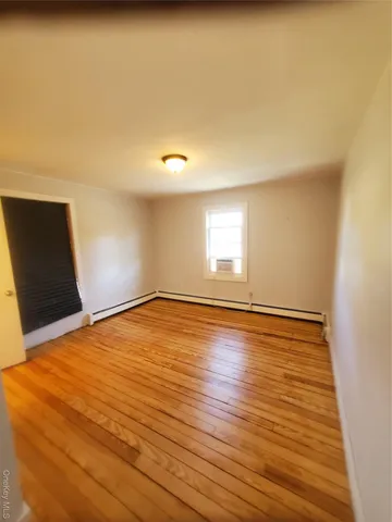 a view of an empty room and wooden floor