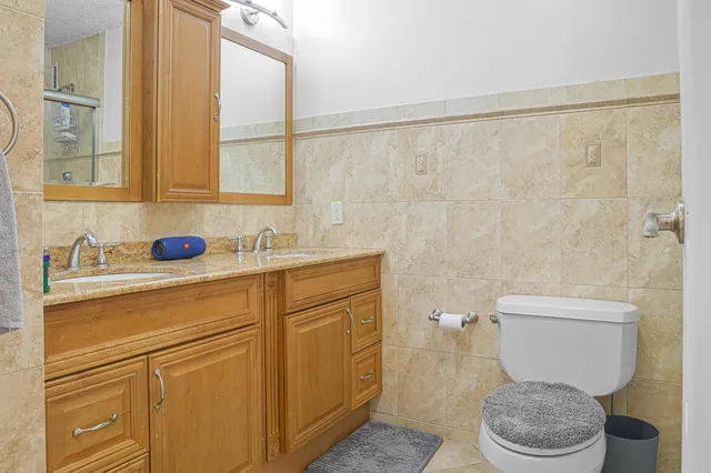 a bathroom with a granite countertop toilet sink and mirror