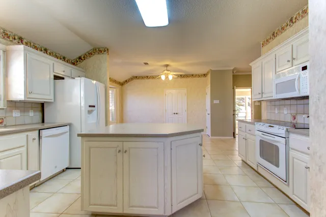 a view of a kitchen with a sink cabinets and entryway