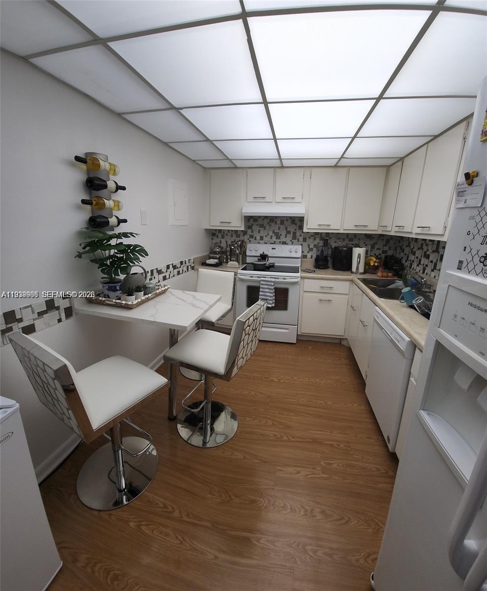 780 Northeast 69th Street, Unit 1207 Miami, FL 33138 - Photo 5 of 12 a kitchen with a sink appliances and cabinets