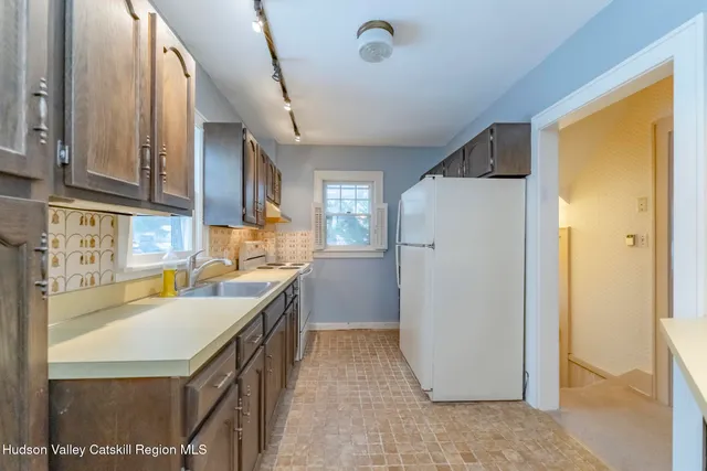 a kitchen that has a sink a refrigerator and a sink