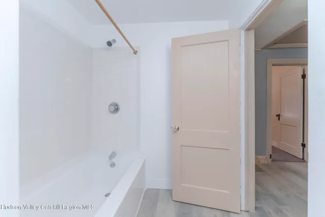a bathroom with a tub shower vanity and a sink