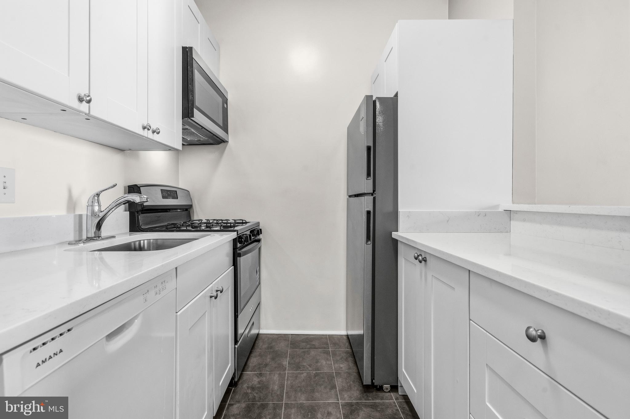 1851 Columbia Road Northwest, Unit 401 Washington, DC 20009 - Photo 13 of 27 a kitchen with a sink and a refrigerator