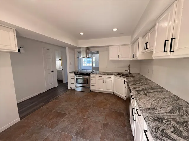 a kitchen with stainless steel appliances granite countertop a stove a sink and a refrigerator