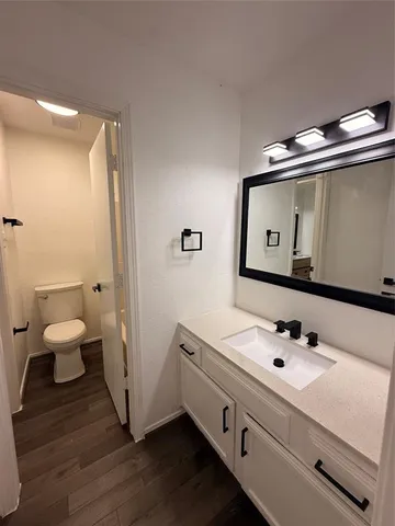 a bathroom with a sink mirror and toilet