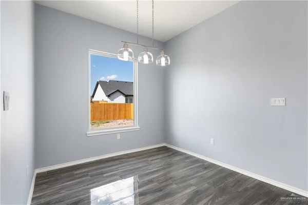 an empty room that has a window and wooden floor