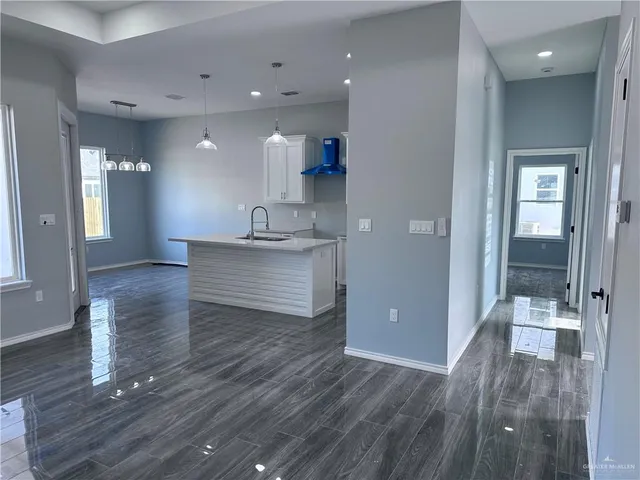 a view of a hallway to a room and wooden floor