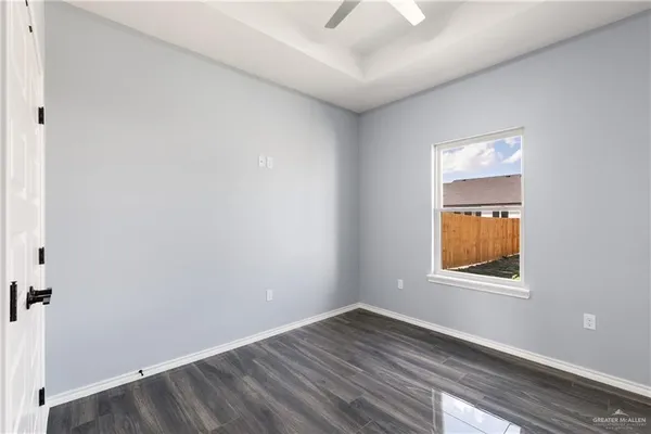 an empty room with a window and wooden floor