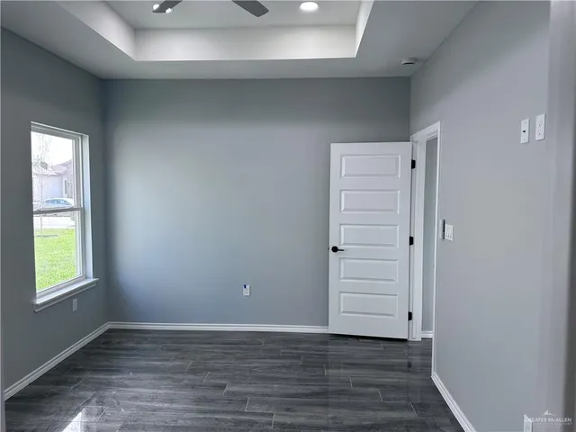 an empty room with wooden closet closet and windows