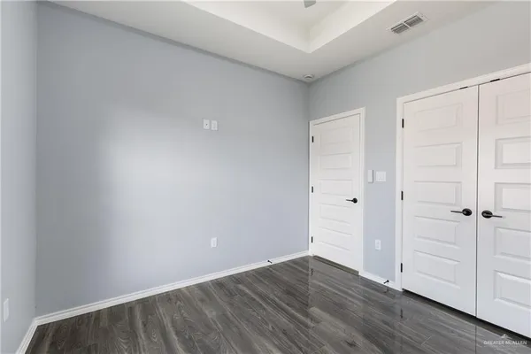 a view of an empty room with wooden floor