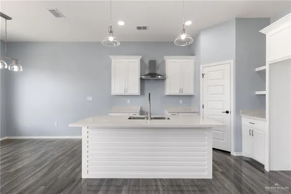 a kitchen with a sink refrigerator and cabinets