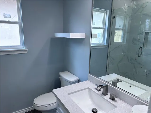 a bathroom with a sink a toilet and window