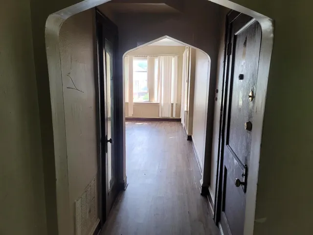 a view of a hallway with wooden floor and glass door