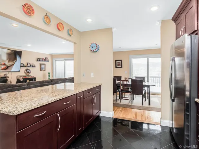 a kitchen with stainless steel appliances granite countertop a table chairs and a refrigerator