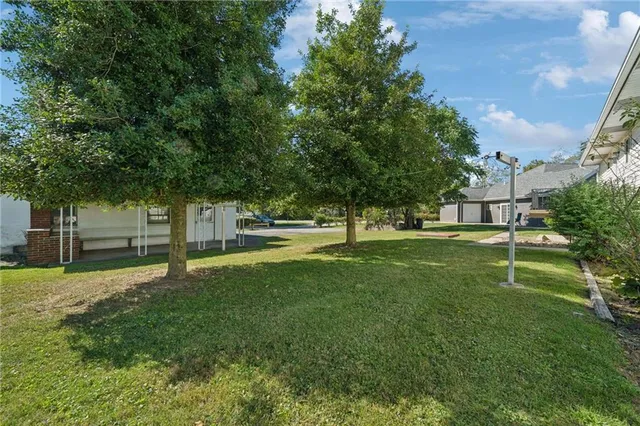 a view of a house with backyard and sitting area