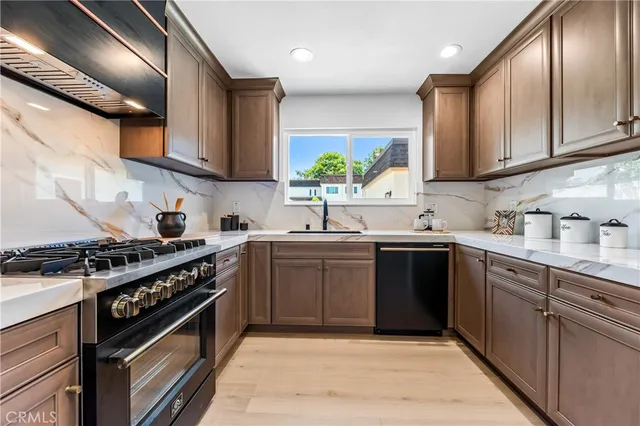 a kitchen with stainless steel appliances granite countertop a sink stove and cabinets