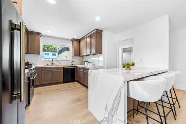 a kitchen with a sink a counter top space cabinets stainless steel appliances and a window