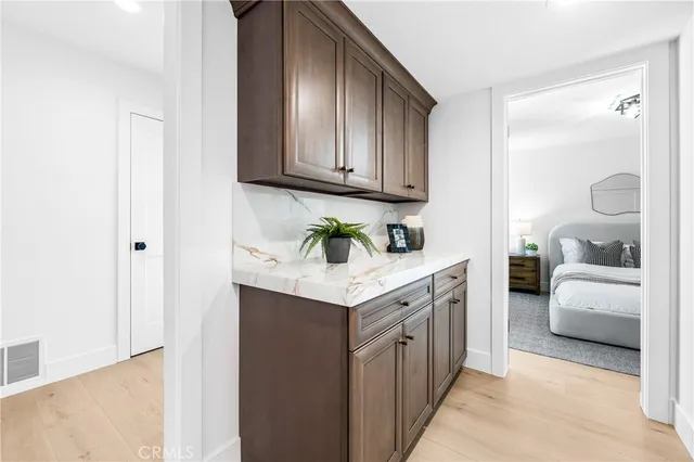 a hallway with granite countertop white cabinets and white appliances