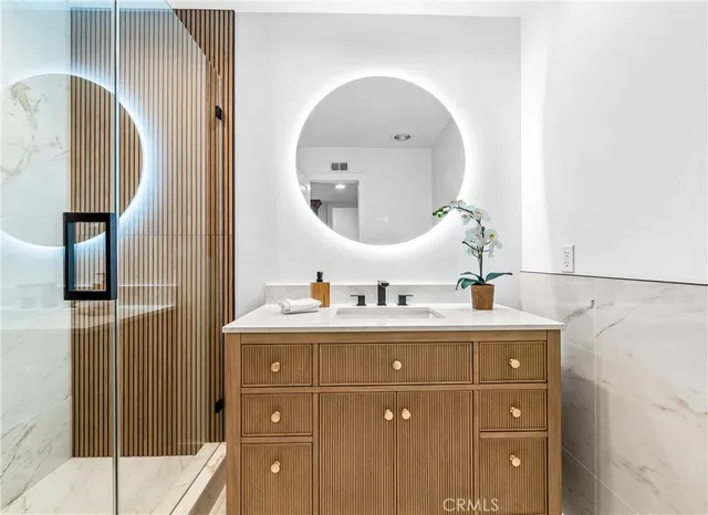 a bathroom with a sink a mirror and a shower