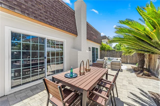 a view of a backyard with table and chairs with a barbeque grill and plants