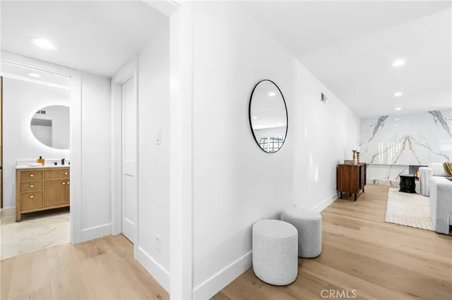 a living room with furniture a mirror and white walls