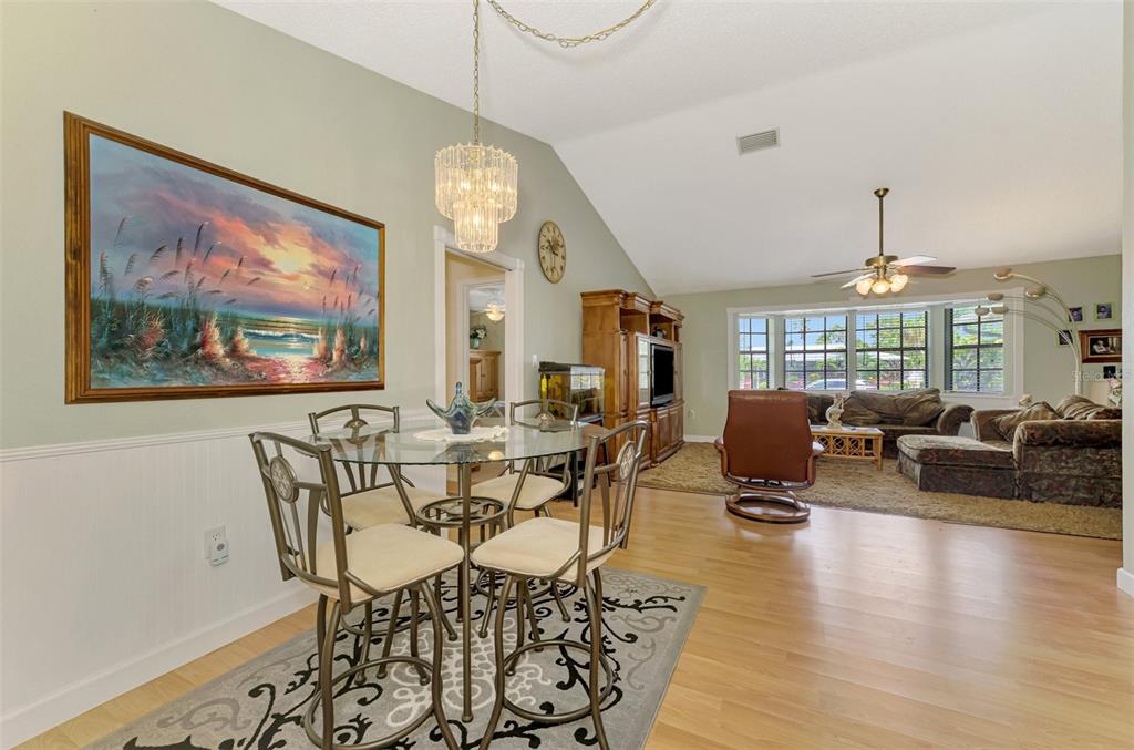 1137 Ponderosa Road Venice, FL 34293 - Photo 13 of 48 a view of a dining room with furniture a chandelier and wooden floor