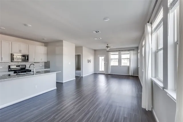 a view of a kitchen with a sink and dishwasher a refrigerator with wooden floor