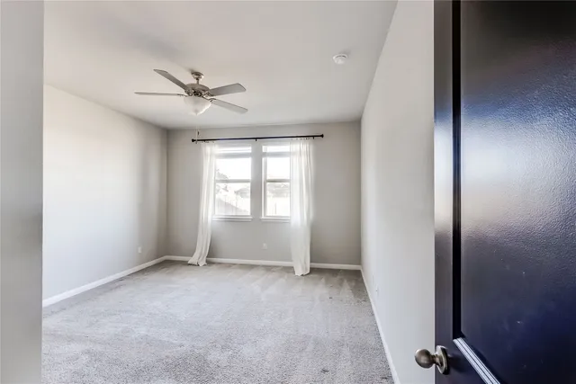 a view of room with a ceiling fan and window