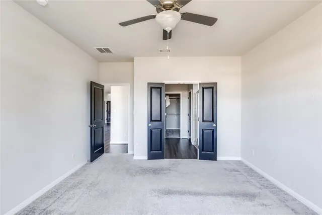 a view of an empty room with a ceiling fan