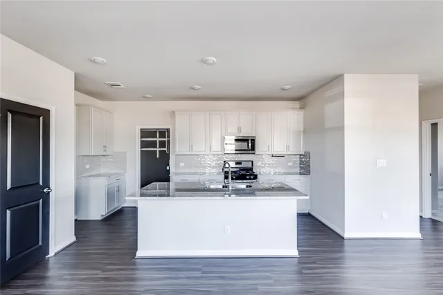 a kitchen with stainless steel appliances a refrigerator and a stove top oven