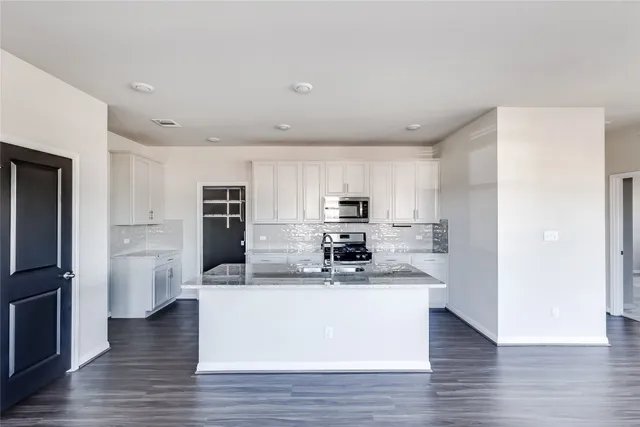 a kitchen with stainless steel appliances a refrigerator and a stove top oven
